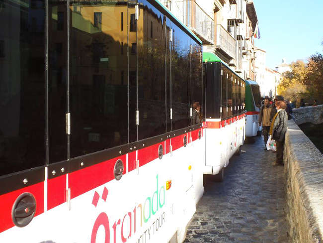 El tren turístico pasa por la Carrera del Darro todos los días. El Ayuntamiento discrimina a los vecinos del Albayzín prohibiendo el paso a las líneas 31 y 35 de microbuses públicos los fines de semana para no estorbar a los que pasean.