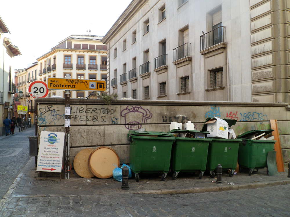 Señalización de hotel con el cartelón del locutorio y junto a los contenedores de basura en Elvira esquina Barrecheguren sin faltar las pintadas en la parte trasera del Banco España.