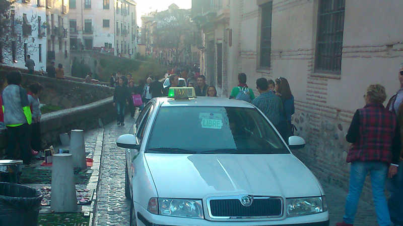 Taxis libre pasando por la Carrera del Darro el fin de semana mientras el transporte público no puede pasar. 2014