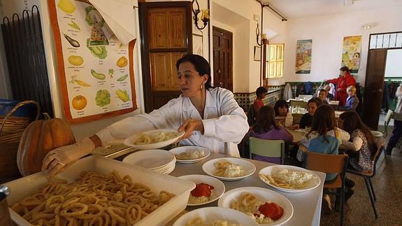 Una empleada del comedor del colegio Gómez Moreno prepara los platos. / GONZÁLEZ MOLERO