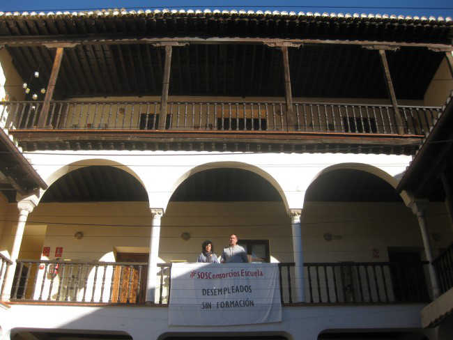 Remedios Alonso y Francisco Tejero posan junto a un pancarta colocada en el patio del Centro Albayzín.