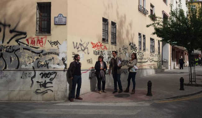 Concejales del PSOE ante unas pintadas en la calle Real de Cartuja.